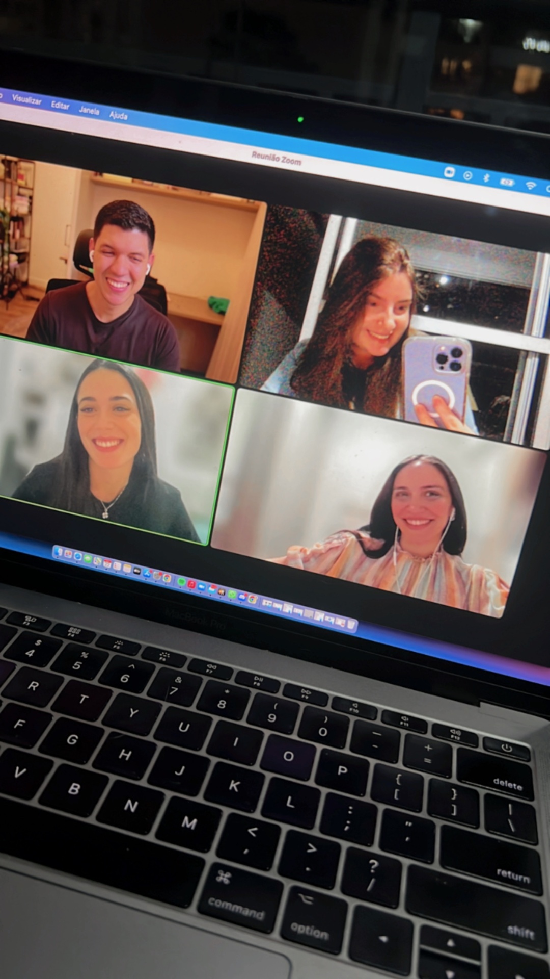Notebook mostrando uma chamada de vídeo em grupo com quatro pessoas sorrindo